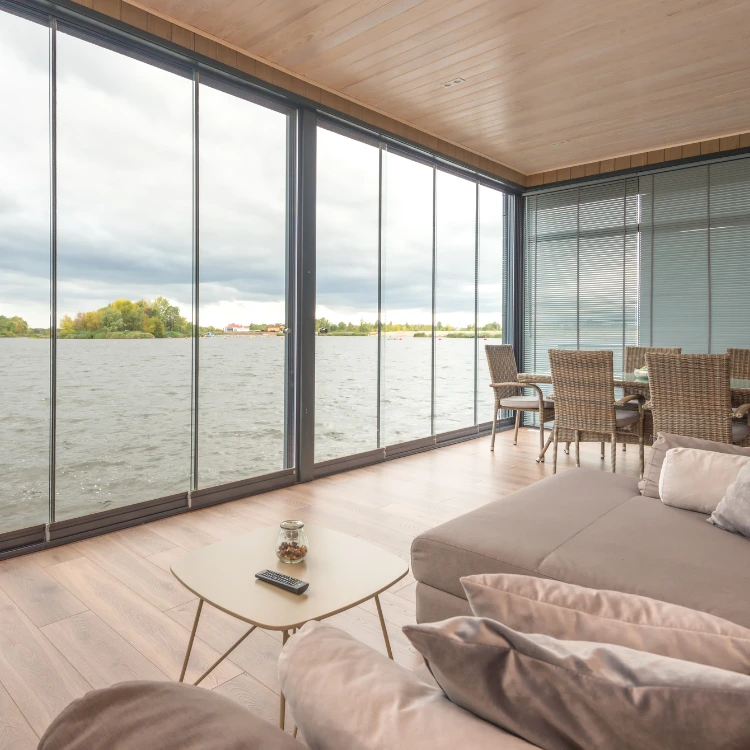 Intérieur d'un salon avec vue d'un lac depuis la baie vitrée